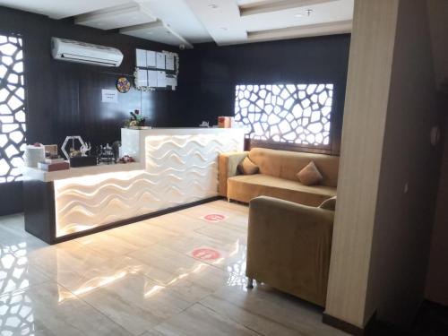 ein Wohnzimmer mit einem Sofa und einer Theke in der Unterkunft Rekaz Aparthotel in Mekka