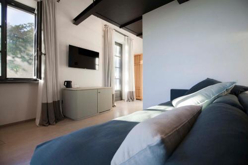 a bedroom with a large bed and a television at Dai Gresy - In Langa in Treiso
