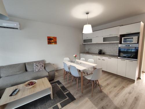a kitchen and living room with a table and a couch at Hatvan Corner Apartments in Debrecen