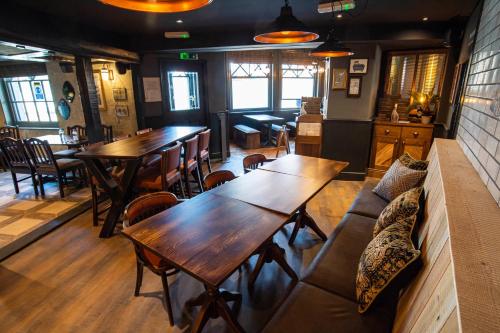 an empty restaurant with wooden tables and chairs at Kings Arms Hotel in Stansted Mountfitchet