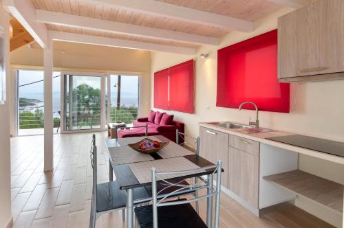 a kitchen with red walls and a table with chairs at Evgenias studio in Gaios