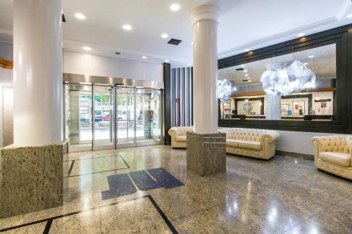 un hall avec colonnes et canapés dans un magasin dans l'établissement Hotel Royal Torino Centro Congressi, à Turin