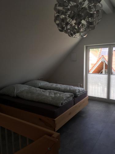a bed in a room with a chandelier at Zeitfrei-Apartments in Kirchheim unter Teck