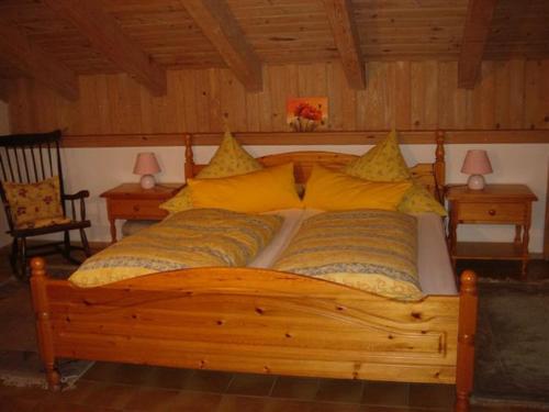 een slaapkamer met een houten bed met gele kussens bij Ferienwohnung Burgenblick in Hopferau