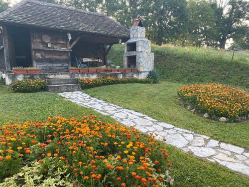 a garden with flowers in front of a building at Holiday Home Rodjak sa sela in Mionica