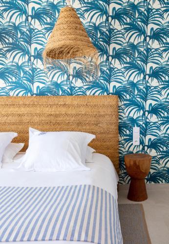 a bedroom with a bed with a blue and white wallpaper at Les Bulles de Mer - Hotel & Spa sur la Plage in Saint-Cyprien