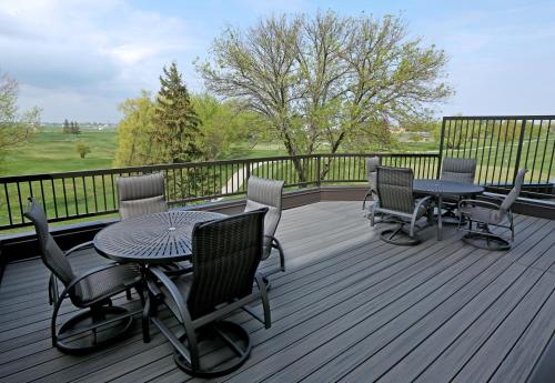 a deck with tables and chairs on a balcony at Holiday Inn & Suites Sioux Falls - Airport by IHG in Sioux Falls