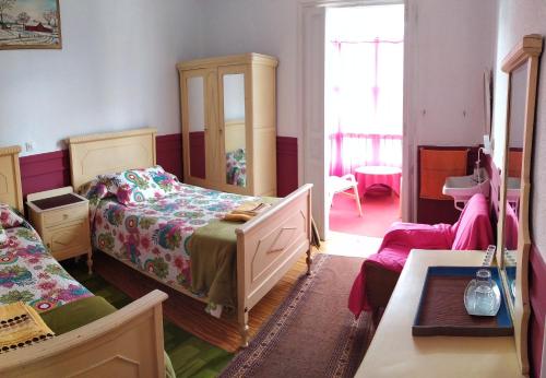 a bedroom with two beds and a mirror and a chair at Pensión Luisito in Santander