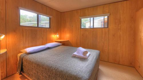 a bedroom with a bed with a towel on it at Crystal Brook Tourist Park in Doncaster East