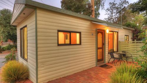 a small shed with a table and a patio at Crystal Brook Tourist Park in Doncaster East
