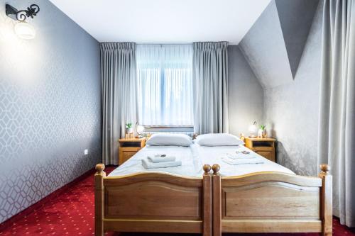 a bedroom with a bed and a window at Tatrzański Dworek in Biały Dunajec
