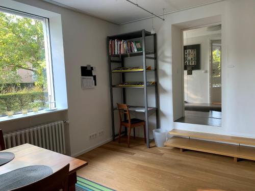 Cette chambre comprend une table, une étagère et une fenêtre. dans l'établissement F80-Die FEINE Ferienwohnung, à Ratisbonne