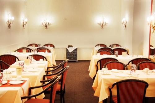 a dining room with white tables and chairs at INA Hotel Royal in Cologne