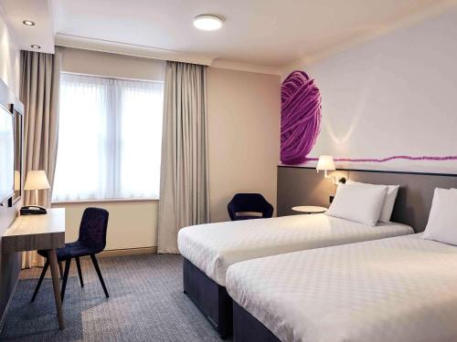 a hotel room with two beds and a desk at Exeter Rougemont Hotel by Sunday in Exeter