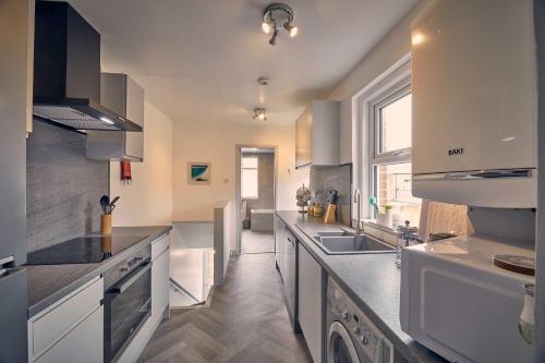 a large kitchen with white counters and a sink at Host & Stay - Silverlinings in Seaton Delaval