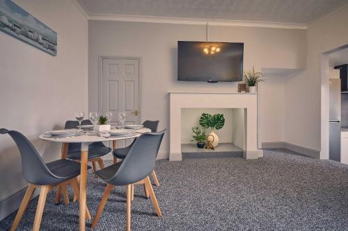 uma sala de jantar com uma mesa e cadeiras e uma lareira em Host & Stay - Silverlinings em Seaton Delaval