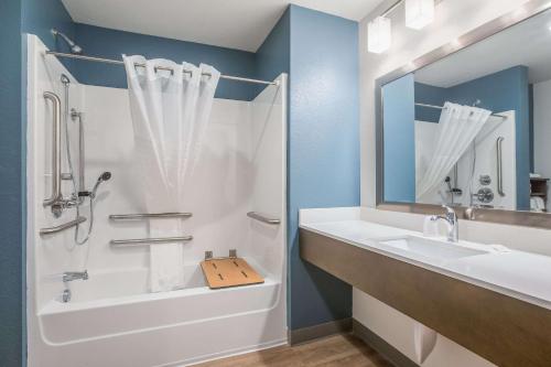 a bathroom with a tub and a sink and a shower at WoodSpring Suites Atlanta McDonough in McDonough