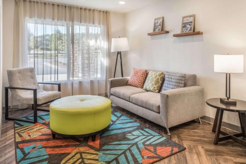 a living room with a couch and a chair at WoodSpring Suites Greenville Haywood Mall in Greenville