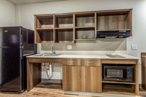 a kitchen with a sink and a refrigerator at WoodSpring Suites Greenville Haywood Mall in Greenville