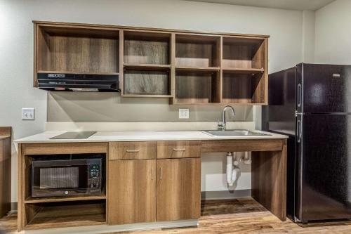a kitchen with a sink and a black refrigerator at WoodSpring Suites Greenville Haywood Mall in Greenville