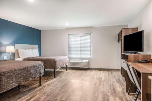 um quarto de hotel com duas camas e uma televisão de ecrã plano em WoodSpring Suites Greenville Haywood Mall em Greenville