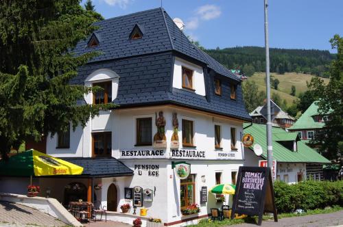 um edifício branco com um telhado preto em Pension U Pece em Pec pod Sněžkou