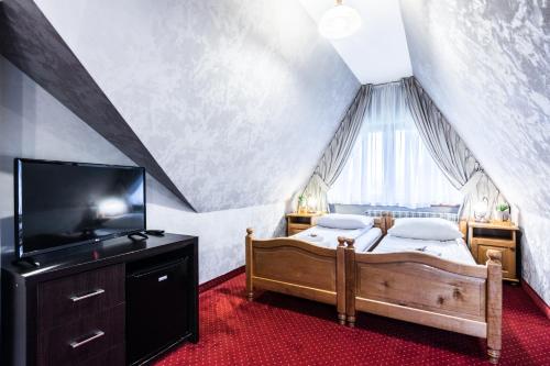 a bedroom with a bed and a dresser at Tatrzański Dworek in Biały Dunajec