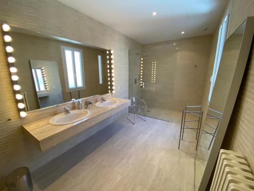 une salle de bain avec deux lavabos et un grand miroir dans l'établissement La Villa Desvaux de Marigny, à Bordeaux