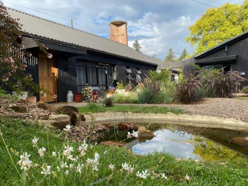 einen Garten mit einem Teich vor einem Haus in der Unterkunft The Croft in Hilton