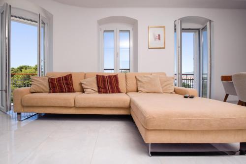 - un grand canapé dans le salon doté de fenêtres dans l'établissement LUXURY APARTMENt DRAGA, à Split