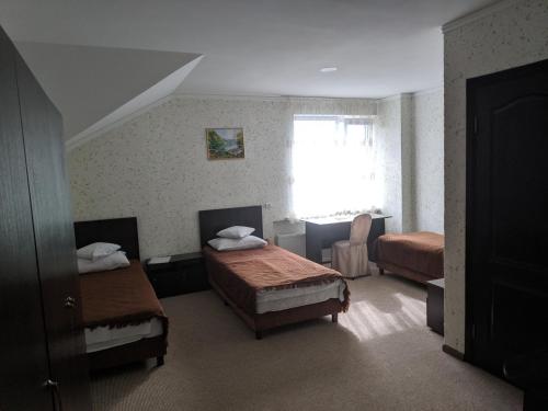 1 dormitorio con 2 camas y ventana en Zhyttedar en Ulanov