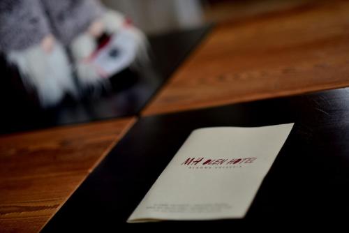a piece of paper sitting on top of a wooden table at MH Olen Boutique Hotel in Alagna Valsesia