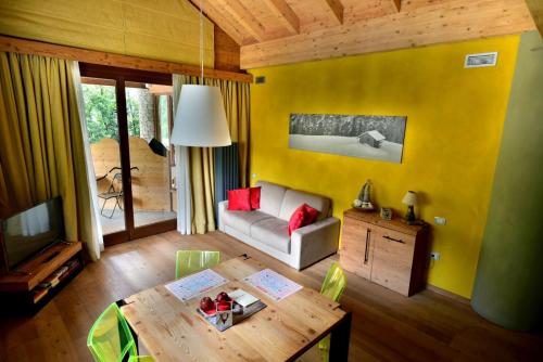 a living room with a table and a yellow wall at MH Olen Boutique Hotel in Alagna Valsesia