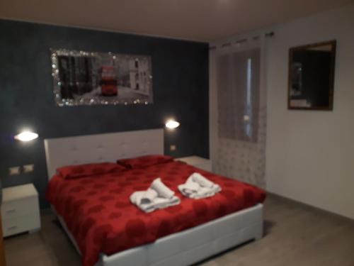 a bedroom with a red bed with white towels on it at B&B Casa Taty in Dolo