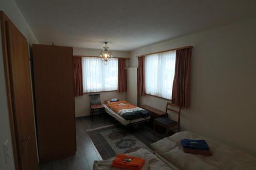a bedroom with two beds and a table in it at Casa Berger in Bolgen