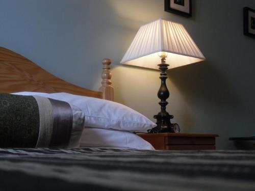 a lamp sitting on a table next to a bed at Church View House F56H977 in Gorteen