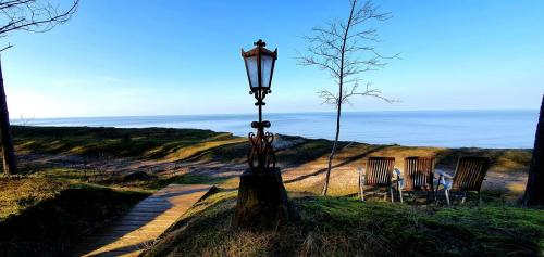 a street light sitting in the grass next to two chairs at Sunset House in Ulmale