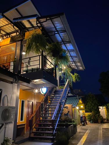 a building with stairs and a balcony at night at The One House in Nan