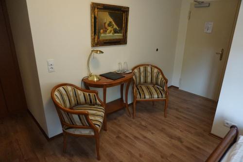 a room with a table and two chairs and a lamp at Landgasthof “Zur Alten Mühle“ in Plaidt