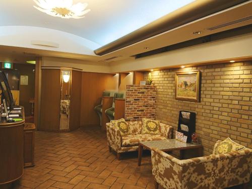 ein Wohnzimmer mit Sofas und Ziegelwand in der Unterkunft Ave Tennoji Hotel in Osaka