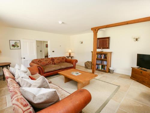 a living room with a couch and a coffee table at Shifford Manor Farm in Witney