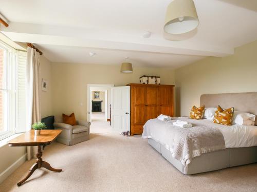 a bedroom with a bed and a couch and a table at Shifford Manor Farm in Witney