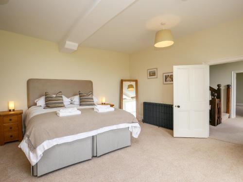 a bedroom with a large bed and a mirror at Shifford Manor Farm in Witney