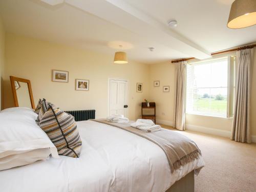a bedroom with a large bed and a window at Shifford Manor Farm in Witney