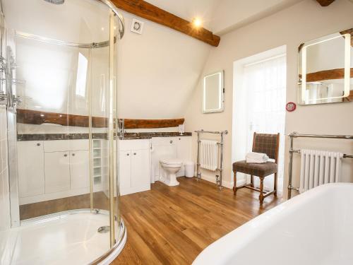 a bathroom with a tub and a toilet at Shifford Manor Farm in Witney