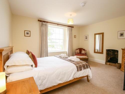 a bedroom with a large bed and a window at Shifford Manor Farm in Witney