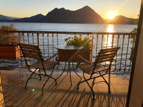a table and chairs on a balcony with a view of the water at Giulia in Verbania