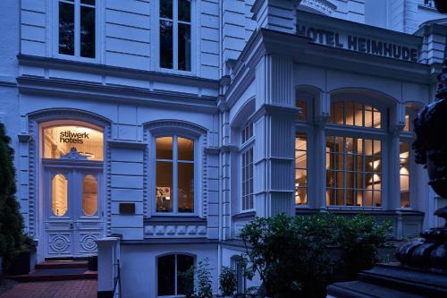 a white building with many windows on a street at stilwerk Hotel Heimhude in Hamburg