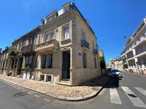 un bâtiment dans une rue avec une voiture garée devant elle dans l'établissement La Villa Desvaux de Marigny, à Bordeaux