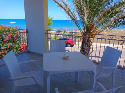 a white table and chairs on a balcony with the ocean at Villa Orsola in Villaputzu